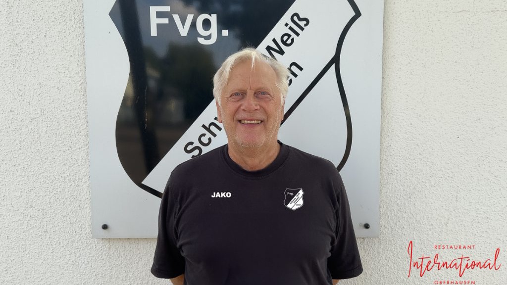 Hans-Günter Bruns vor dem Logo von SW Alstaden.