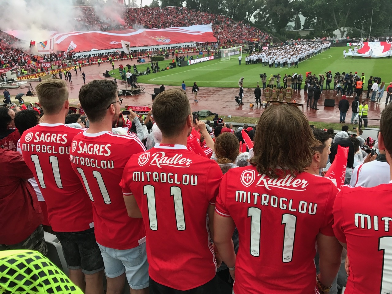 [{"clang_id":1,"value":"Fußballstadion: Mehrere rote Trikots mit der Nummer 11 im Vordergrund, Fans im Hintergrund, Spiel auf dem Rasen."}]