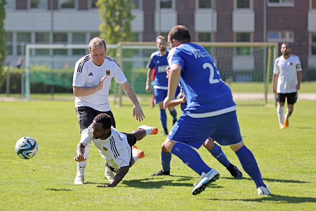 [{"clang_id":1,"value":"Fußballspiel: Spieler mit Ball, ein Spieler rutscht, zwei weitere Spieler im Hintergrund, Rasenplatz und Gebäude im Hintergrund."}]