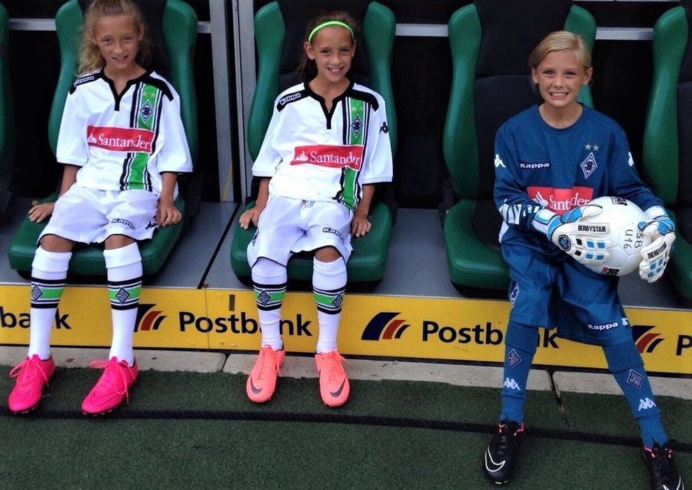 [{"clang_id":1,"value":"Drei junge Fußballspielerinnen sitzen auf Stadionbänken. Links und Mitte tragen sie grüne und weiße Trikots, rechts eine blaue Torwartuniform."}]