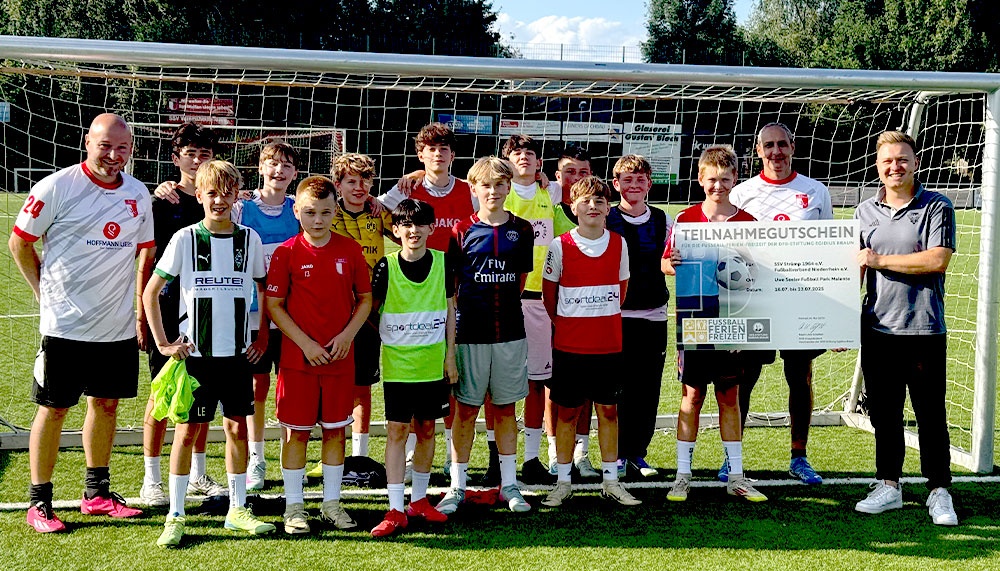[{"clang_id":1,"value":"Fußballmannschaft mit Trainer und Betreuern vor einem Fußballtor. Alle schauen in die Kamera. Im Hintergrund ein Werbebanner."}]