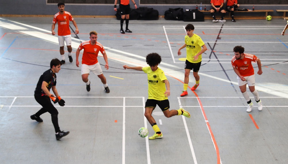 [{"clang_id":1,"value":"Futsal-Spiel in Sporthalle. Spieler in gelben und roten Trikots kämpfen um Ball. Ein Schiedsrichter ist ebenfalls zu sehen. Linien markieren Spielfeld."}]