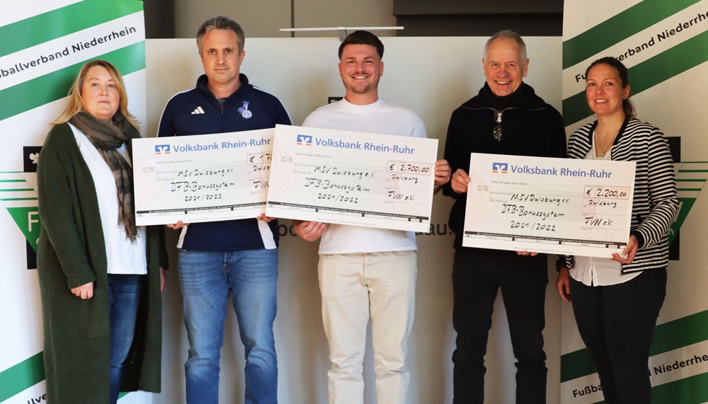 [{"clang_id":1,"value":"Sechs Personen posieren mit Schecks. Im Hintergrund eine grüne Wand mit Aufschrift \"Fußballverband Niederrhein\" und Werbebanner der \"Volksbank Rhein-Ruhr\"."}]