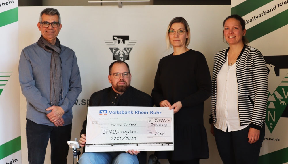 [{"clang_id":1,"value":"Vier Personen präsentieren einen Scheck der Volksbank Rhein-Ruhr über 2.700 Euro an FV Nie. Im Hintergrund ein Logo des Fußballverbands Niederrhein."}]