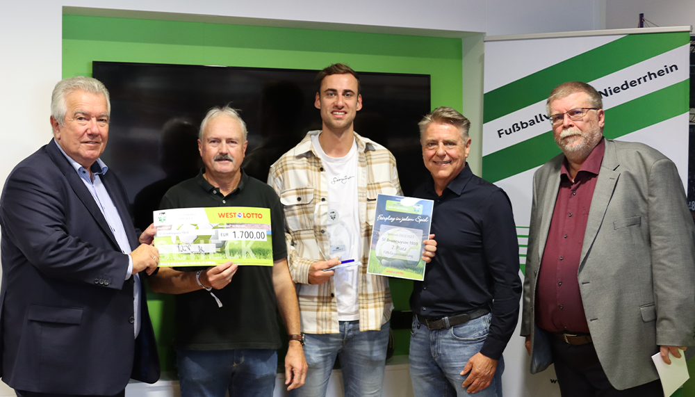 [{"clang_id":1,"value":"Fünf Männer stehen nebeneinander und halten Schecks in der Hand. Im Hintergrund eine grüne Wand mit Schriftzug \"Fußballverein\"."}]