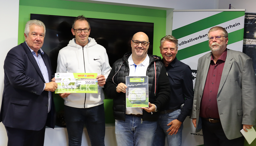 [{"clang_id":1,"value":"Fünf Männer stehen nebeneinander, halten Schecks und eine Plakette. Im Hintergrund ein Banner mit dem Schriftzug \"Fußballverband\"."}]