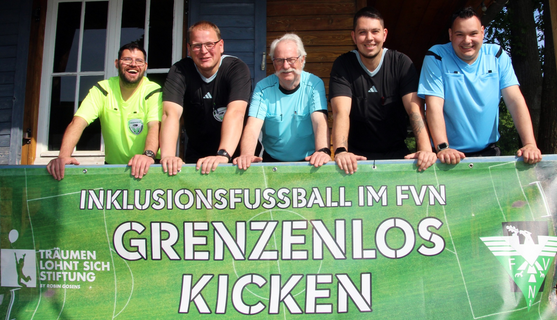 [{"clang_id":1,"value":"Fünf Männer vor grünem Banner mit Aufschrift \"Inklusionsfussball im FVN\" und \"Grenzenlos Kicken\". Männer tragen Sportkleidung, lächeln. Logo \"Träumen lohnt sich Stiftung\" und FVN-Logo zu sehen."}]