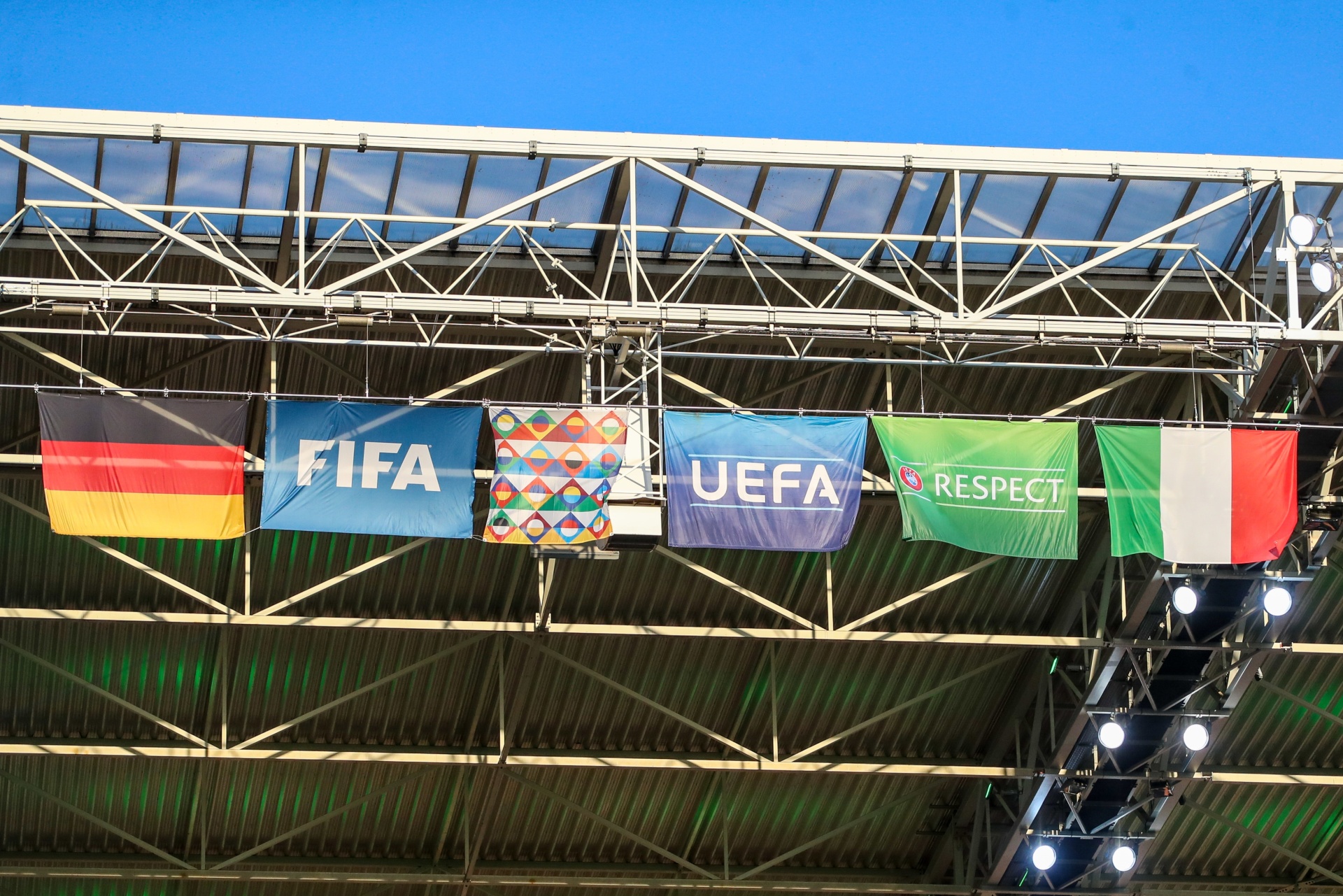 [{"clang_id":1,"value":"Fußballstadion: Unter der Dachkonstruktion hängen Flaggen von FIFA, UEFA, Deutschland, Brasilien, Frankreich und Italien."}]