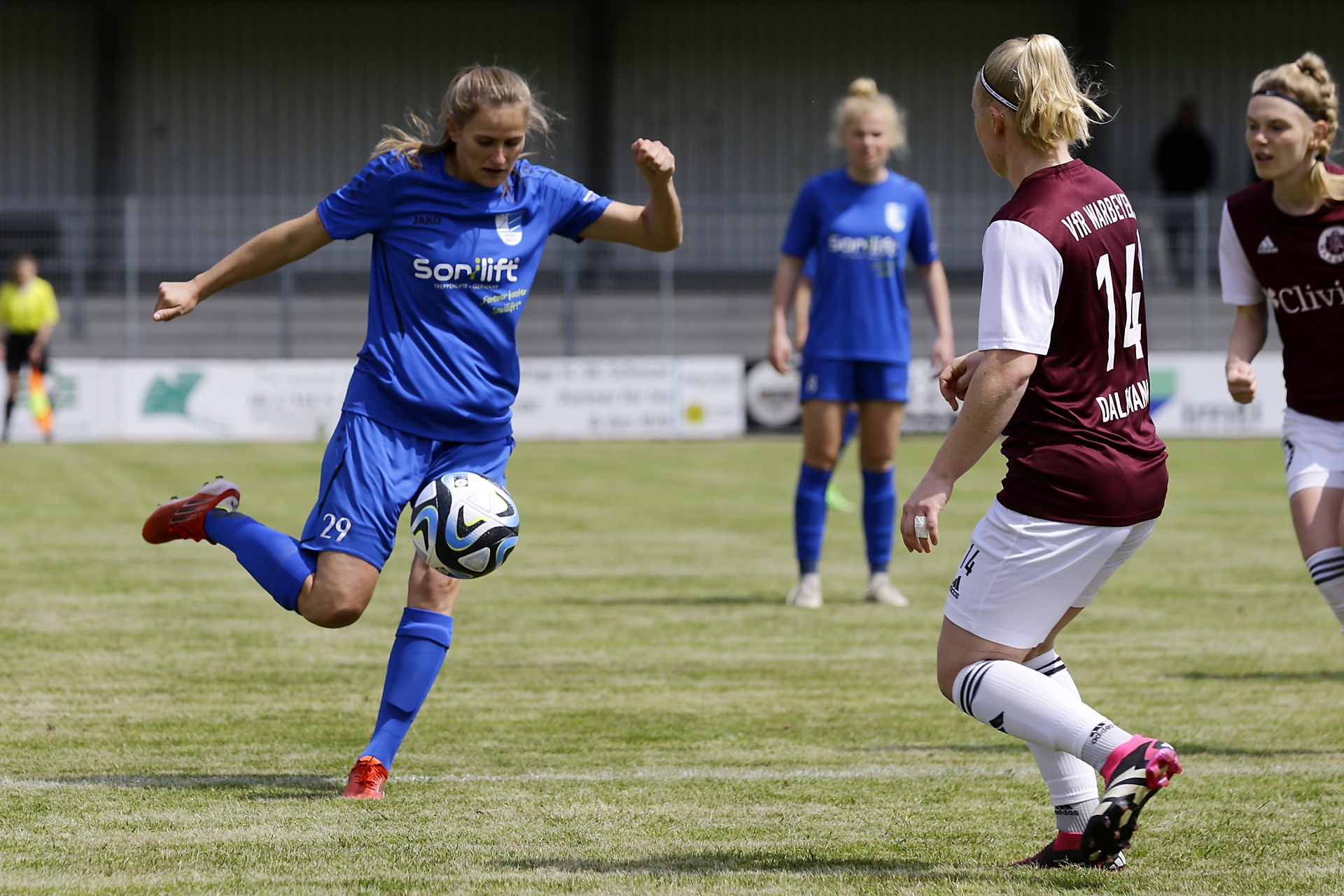 [{"clang_id":1,"value":"Fußballspiel: Zwei Frauen kicken einen Ball auf einem grünen Rasenfeld. Eine Spielerin trägt blaues Trikot mit Startnummer 29, die andere ein rot-weißes Trikot mit Nummer 14."}]