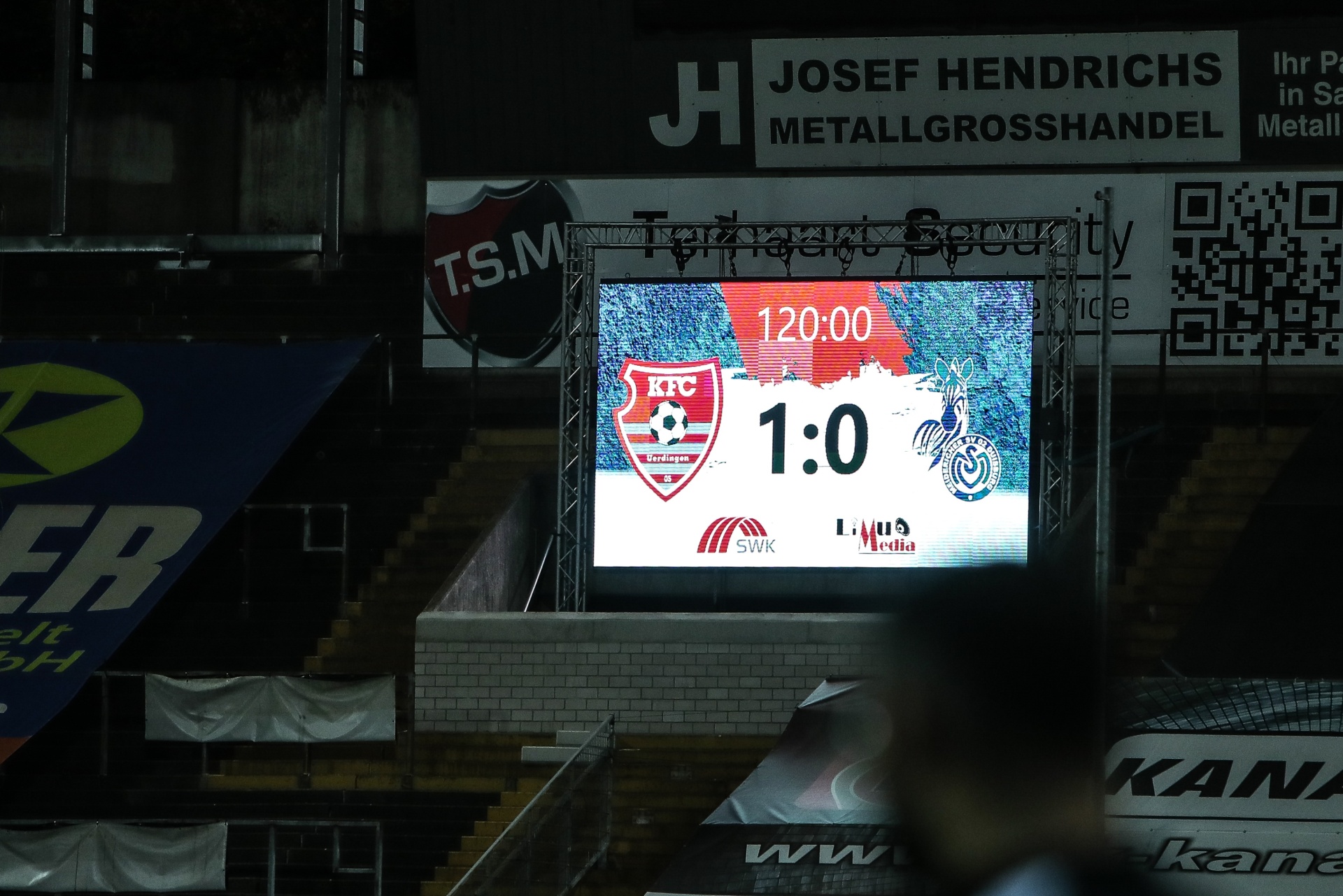 [{"clang_id":1,"value":"Stadion-Scoreboard zeigt Fußballspiel KFC Uerdingen gegen SV Lippstadt. Ergebnis 1:0, Spielzeit 120:00. Werbung für Josef Hendrichs Metallgroßhandel."}]