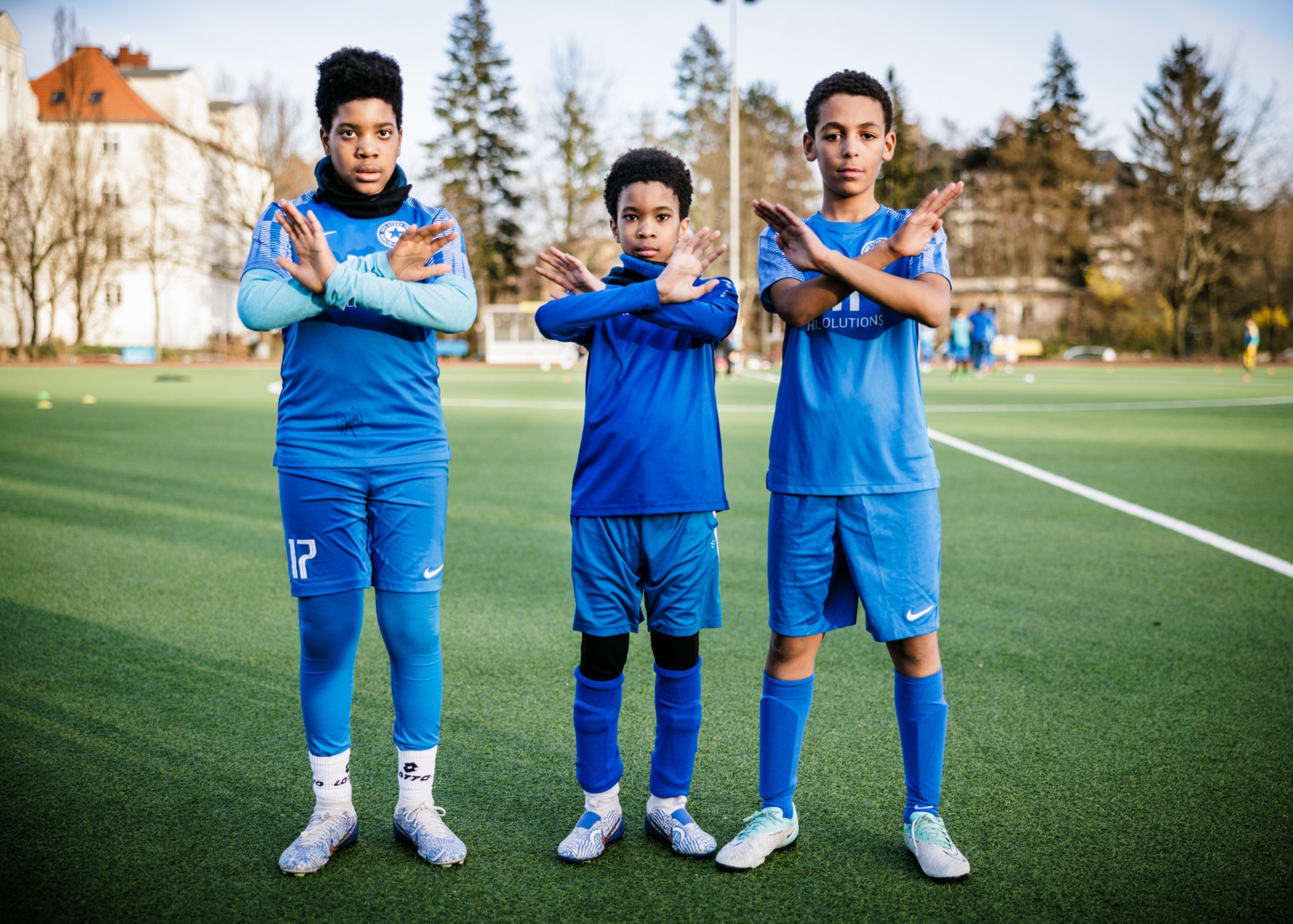 [{"clang_id":1,"value":"Drei Jungen im blauen Fußballtrikot stehen auf einem Rasenfeld. Sie machen alle die Geste, als würden sie applaudieren, indem sie ihre Hände vor das Gesicht halten."}]