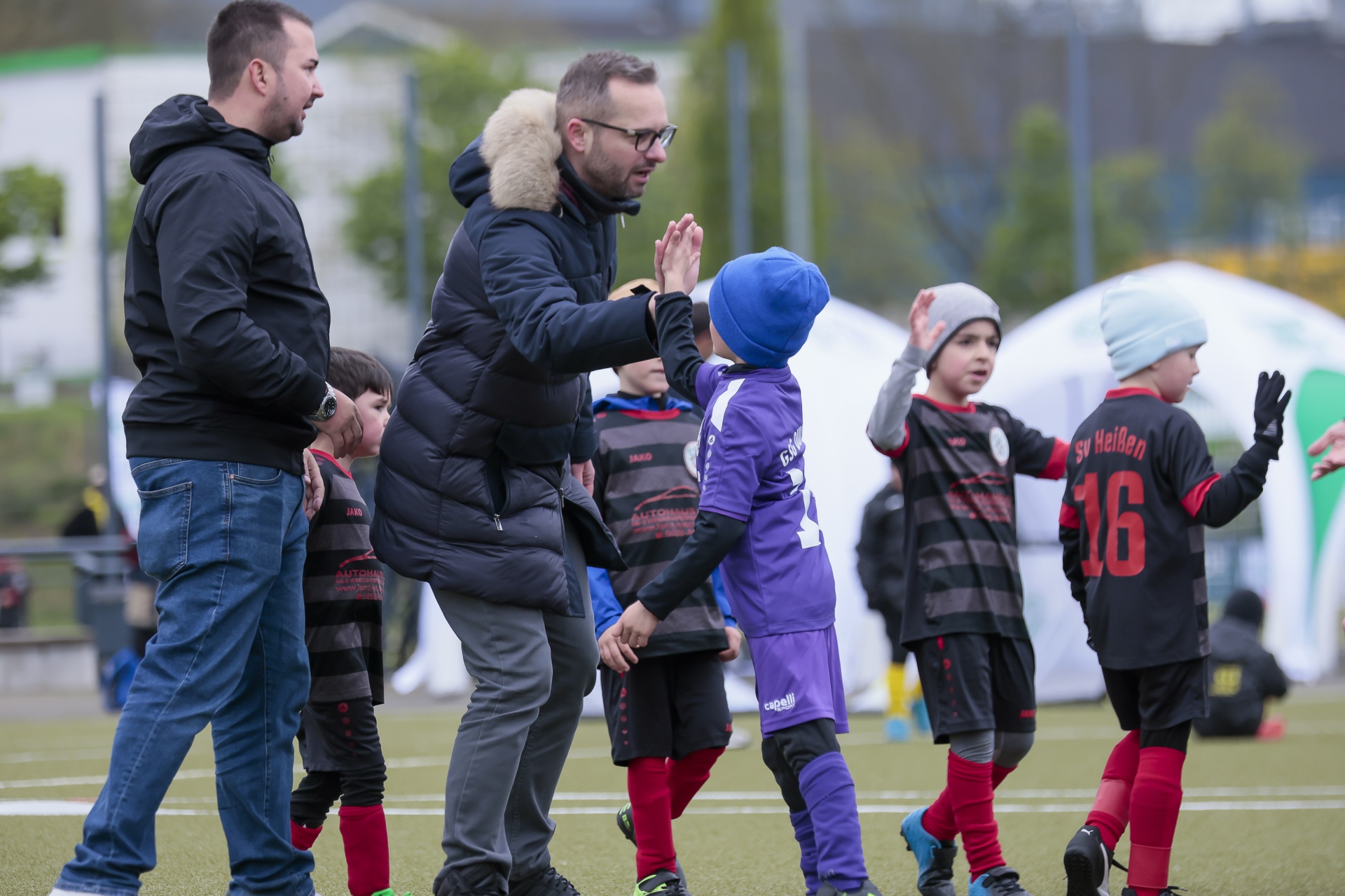 [{"clang_id":1,"value":"Fußballtraining: Zwei Erwachsene und vier Kinder stehen auf einem Fußballfeld. Die Kinder tragen Sportkleidung, die Erwachsenen Winterjacken."}]
