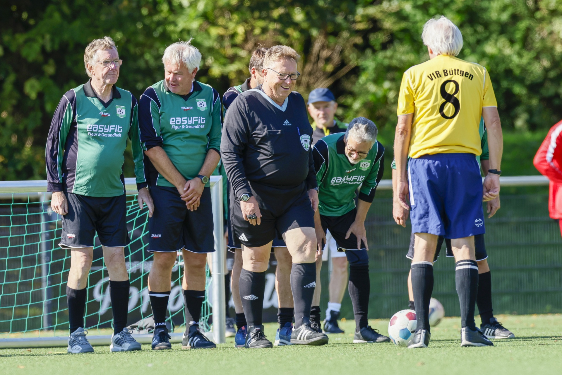 [{"clang_id":1,"value":"Fünf Männer stehen auf einem Fußballfeld. Vier tragen grüne Sportkleidung, einer gelb-schwarzes Trikot mit Nummer 8. Ein Mann in Schwarz ist Schiedsrichter."}]