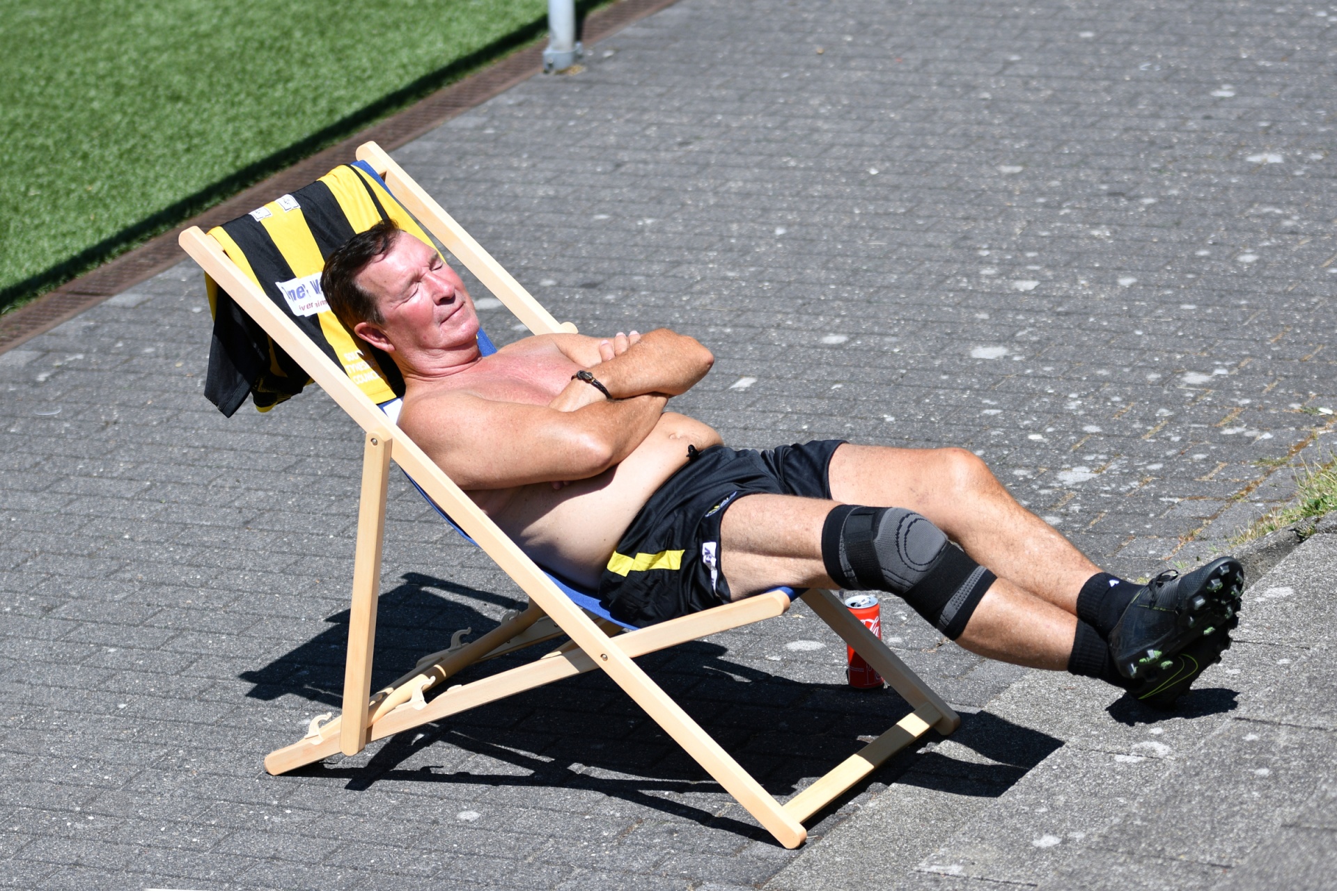 [{"clang_id":1,"value":"Muskulöser Mann liegt barhäutig in einer Strandliege, sonnt sich. Trägt kurze Hose und Schützer, eine Serviette hängt an der Liege. Rasen im Hintergrund."}]