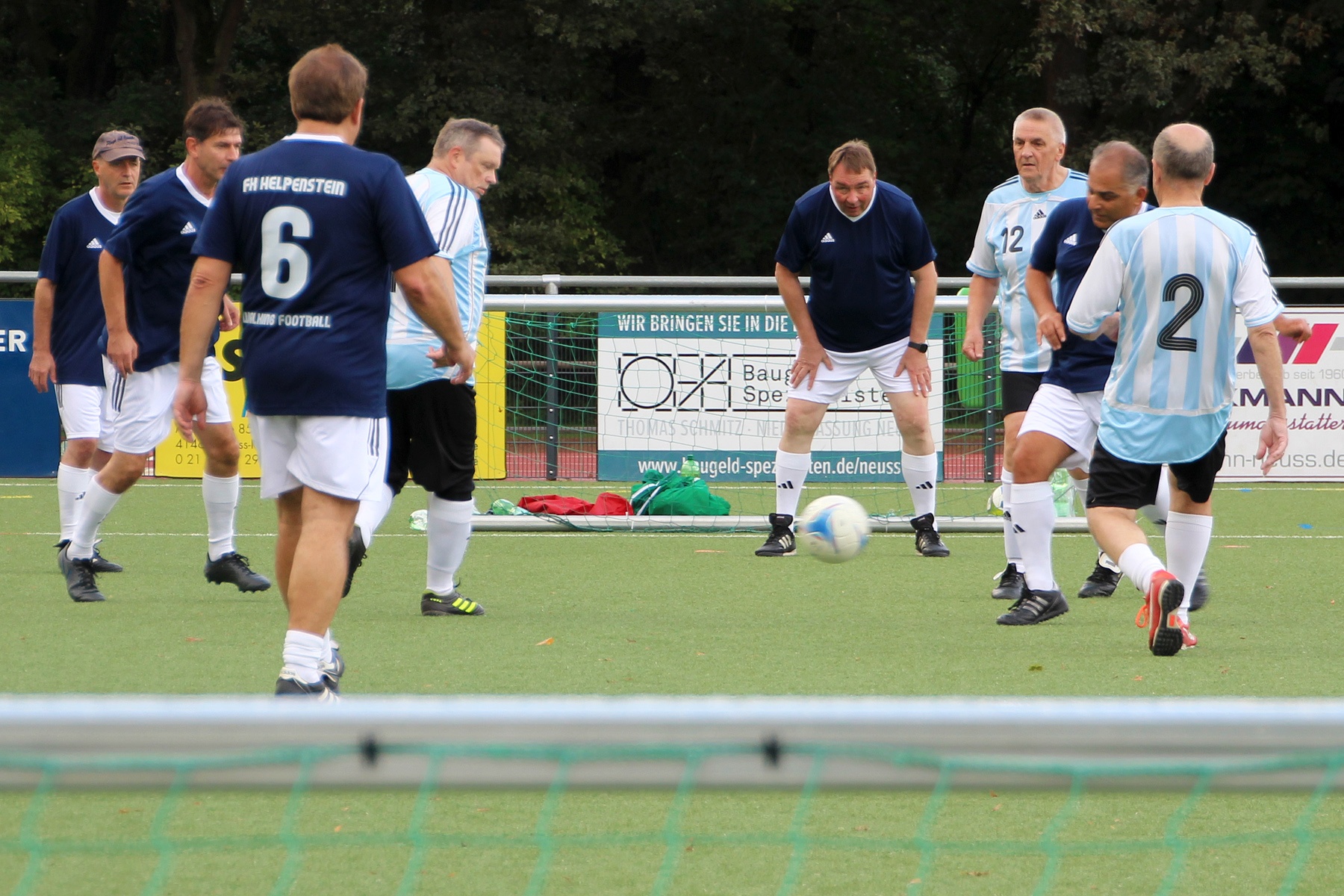 [{"clang_id":1,"value":"Fußballspiel: Herrenmannschaften in blau-gelb und hellblau-weiß kämpfen um den Ball auf grünem Rasen. Im Hintergrund Werbebanner."}]