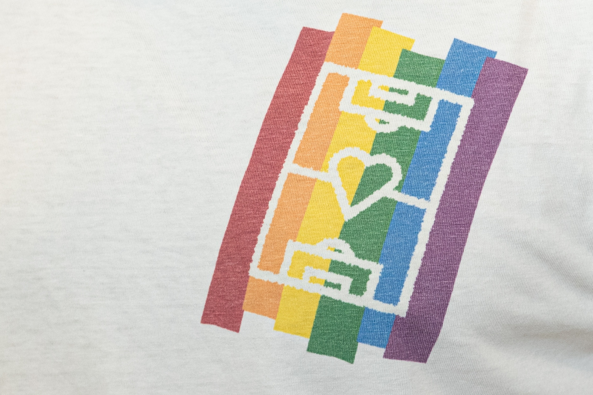 [{"clang_id":1,"value":"Weißes T-Shirt mit Aufdruck: Regenbogenfarbenes Rechteck mit dem Wort \"LOVE\" und einem Herzsymbol darin."}]