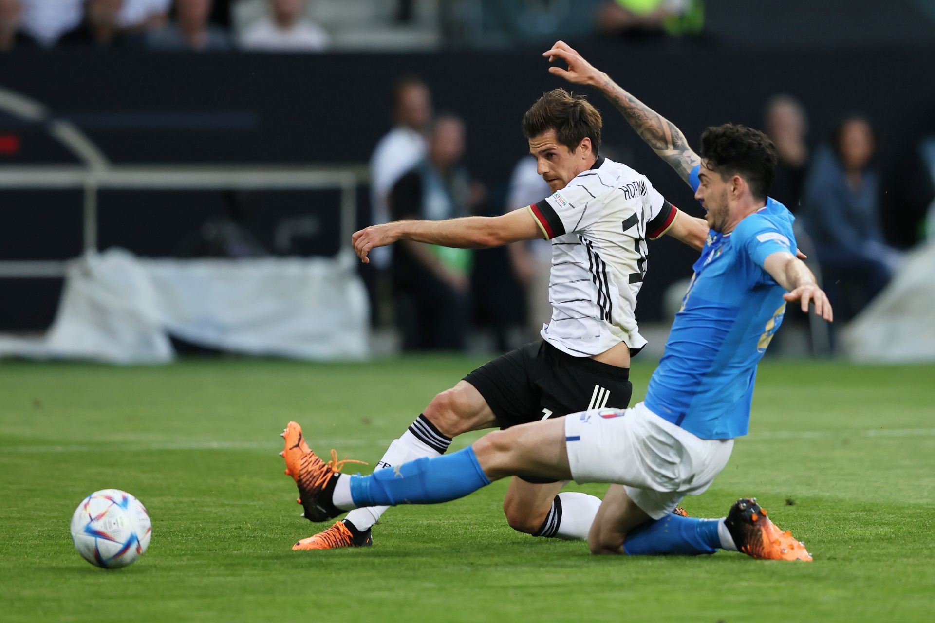 [{"clang_id":1,"value":"Zwei Fußballspieler in Aktion. Ein Spieler in weiß-schwarzem Trikot schießt auf den Ball, während ein Spieler in blauem Trikot ihn anrempelt. Rasen im Hintergrund."}]