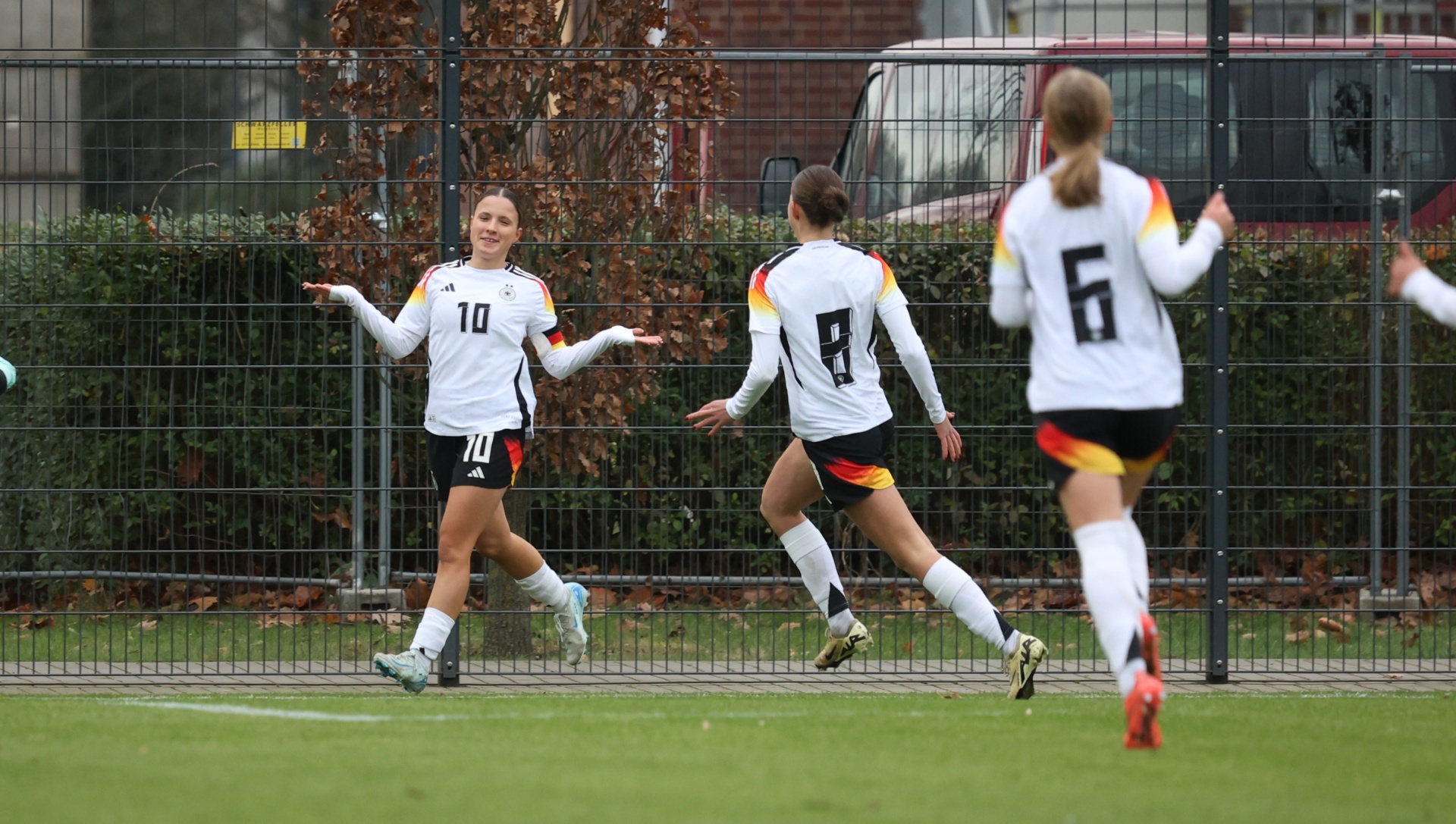 [{"clang_id":1,"value":"Drei Fußballspielerinnen auf grünem Rasen. Links trägt eine Spielerin den Trikotnummer 10, in der Mitte 9 und rechts 6. Alle tragen deutsche Nationaltrikots."}]