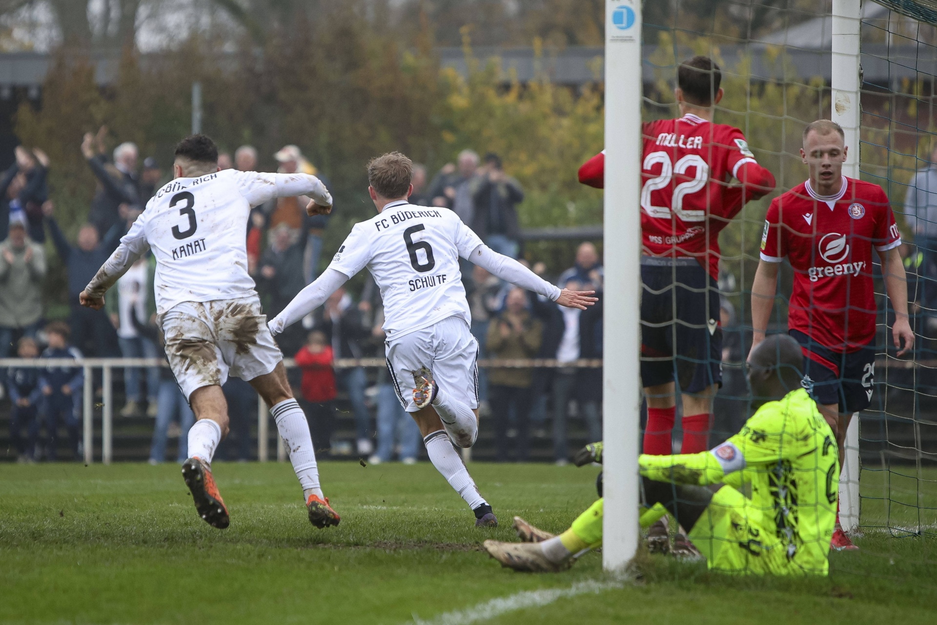 [{"clang_id":1,"value":"Zwei Fußballspieler in Weiß feiern mit hochgestreckten Armen ein Tor. Im Hintergrund steht der gegnerische Torwart in grüner Kleidung und Feldspieler in Rot. Zuschauer sind angedeutet."}]