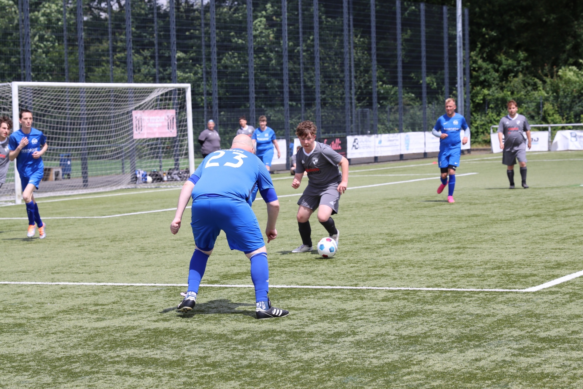 [{"clang_id":1,"value":"Fußballspiel: Zwei Spieler kämpfen um den Ball. Im Hintergrund weitere Spieler und ein Zaun. Rasenplatz an einem sonnigen Tag."}]