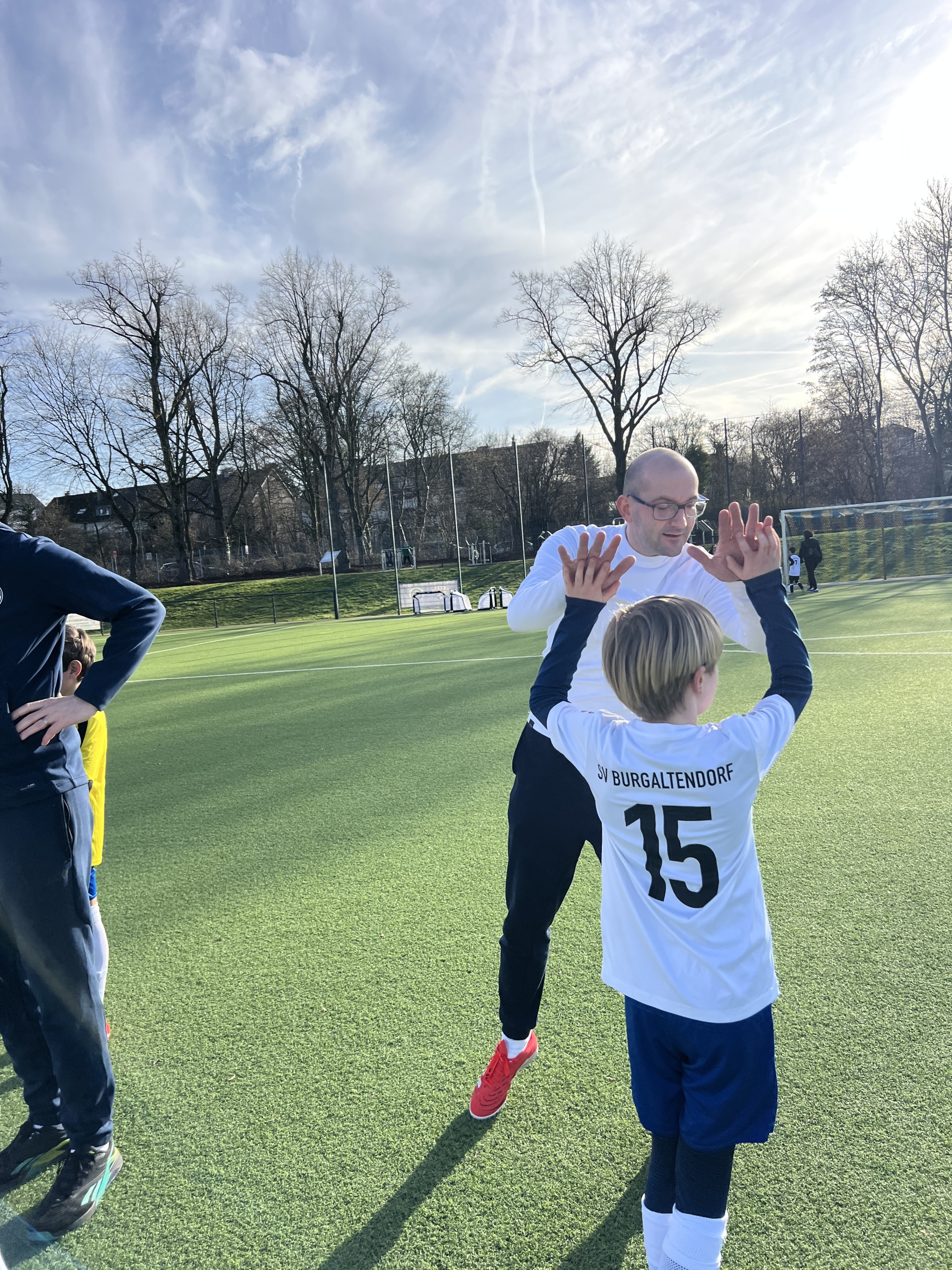 [{"clang_id":1,"value":"Zwei Fußballspieler auf grünem Rasenfeld. Ein Spieler in weißem Trikot mit Nummer 15 steht mit erhobenen Armen, der andere liegt am Boden."}]