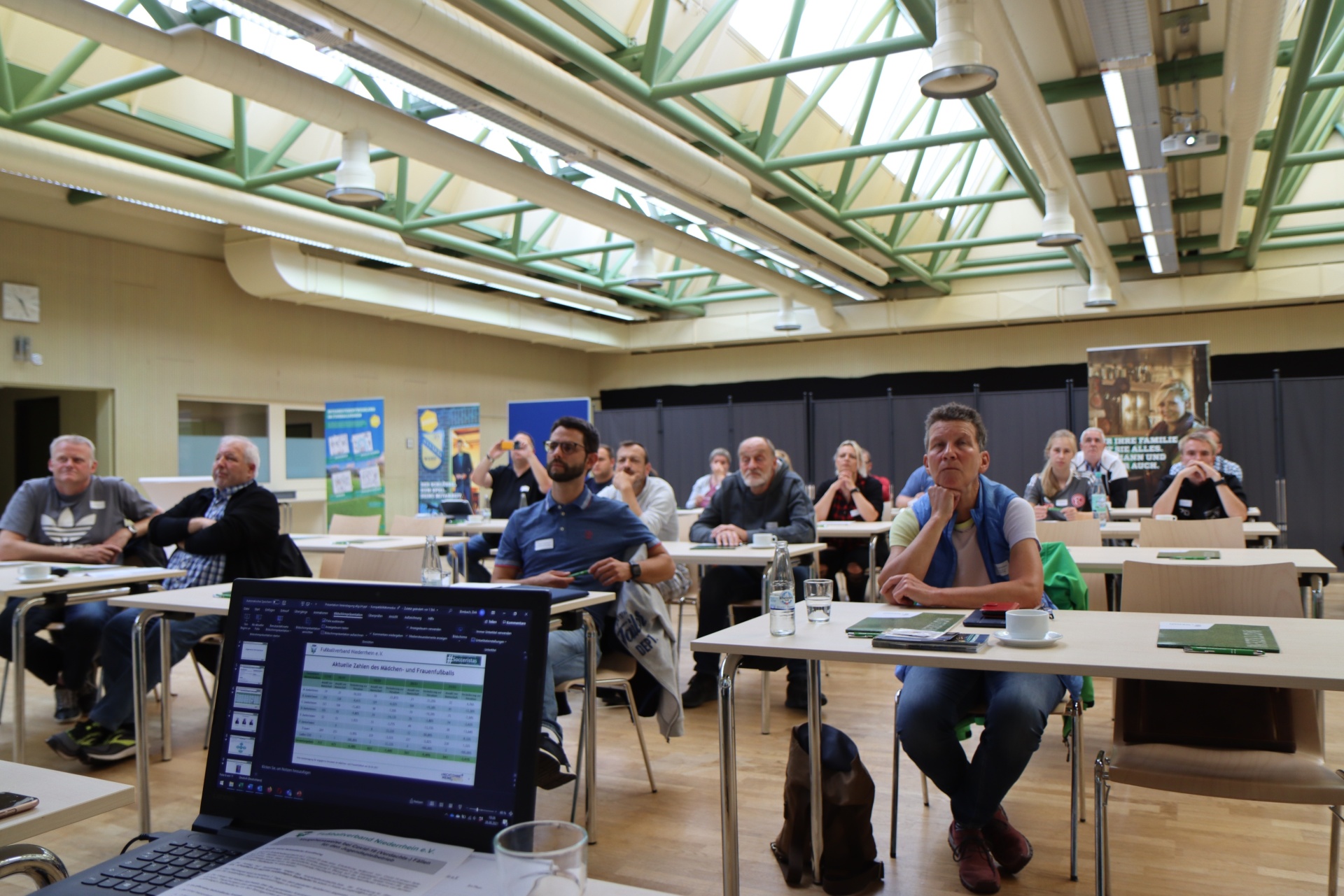 [{"clang_id":1,"value":"Raum mit Teilnehmern an Tischen, lernen. Laptop geöffnet, Präsentation im Fokus. Industrieller Stil, sichtbare Stahlkonstruktion der Decke."}]
