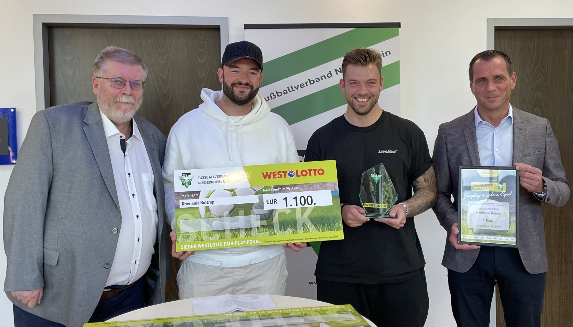 [{"clang_id":1,"value":"Vier Männer stehen lächelnd vor einem Banner. Zwei halten Schecks und Urkunden, vermutlich Preisgelder für einen Wettbewerb."}]