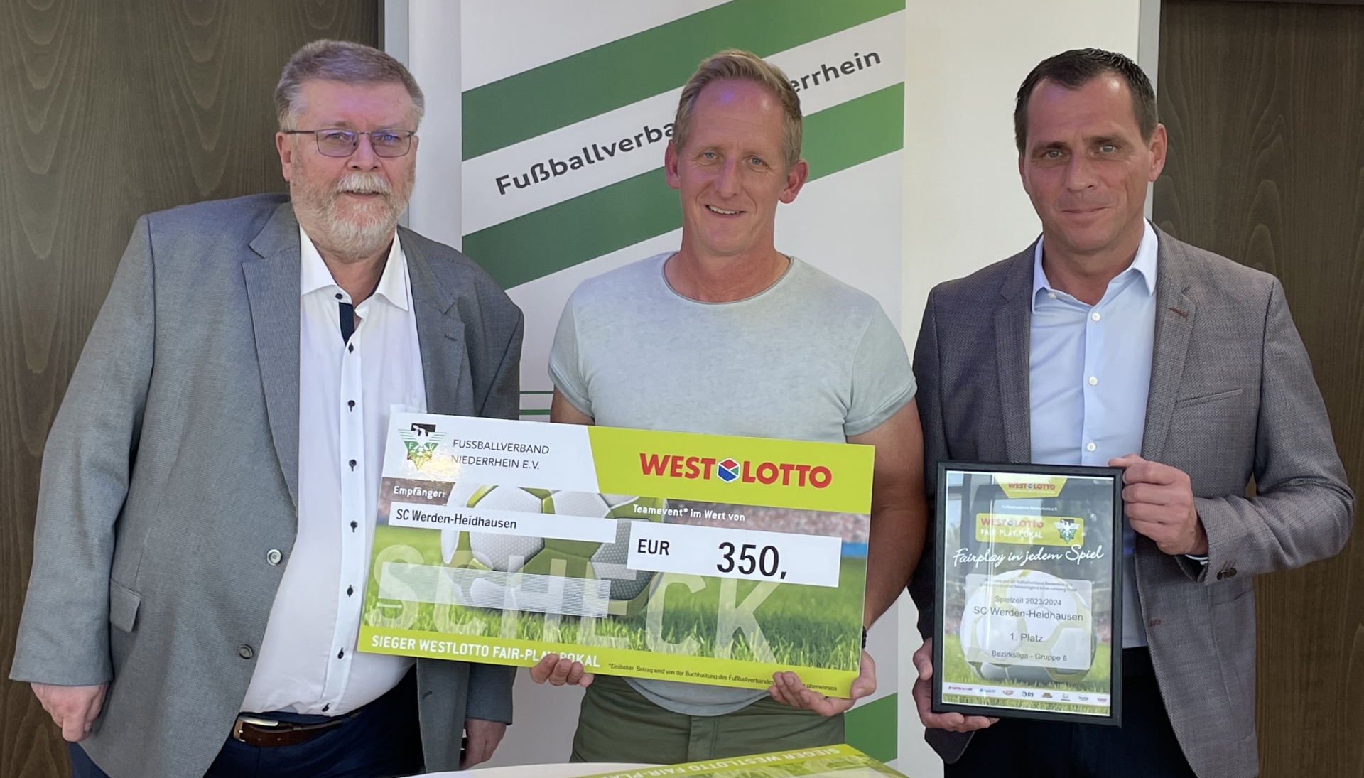 [{"clang_id":1,"value":"Drei Männer präsentieren einen Scheck über 350 Euro und eine Urkunde. Im Hintergrund ein Banner mit Fußballbezug."}]