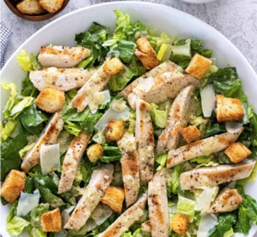 [{"clang_id":1,"value":"Caesar Salat mit gegrilltem Hähnchen, Römersalat, Croutons und Parmesanraspeln auf weißem Teller. Kleine Schale Croutons im Hintergrund."}]