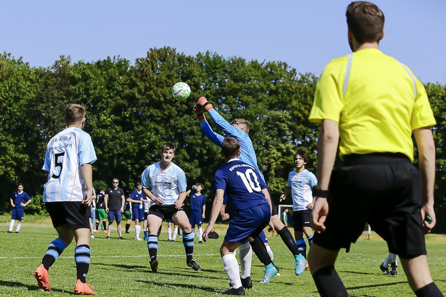 [{"clang_id":1,"value":"Fußballspiel. Spieler in blauen und hellblauen Trikots kämpfen um den Ball. Im Hintergrund ein Linienrichter in gelb."}]