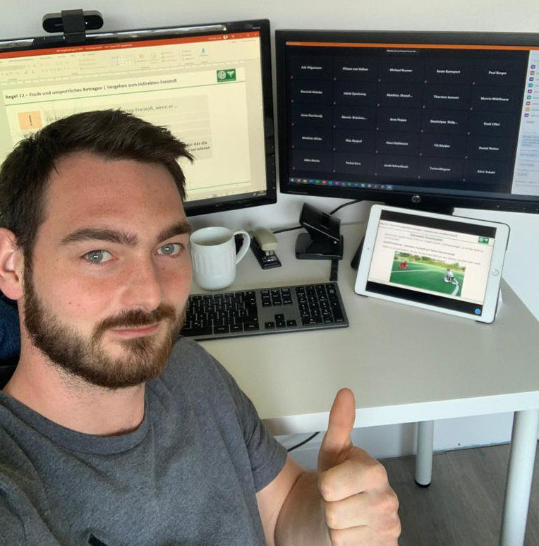 [{"clang_id":1,"value":"Mann sitzt lächelnd vor Computer mit zwei Monitoren und Tablet. Er zeigt Daumen hoch. Auf den Bildschirmen sind Textdokumente und eine Tabelle zu sehen. Eine Tasse steht auf dem Schreibtisch."}]